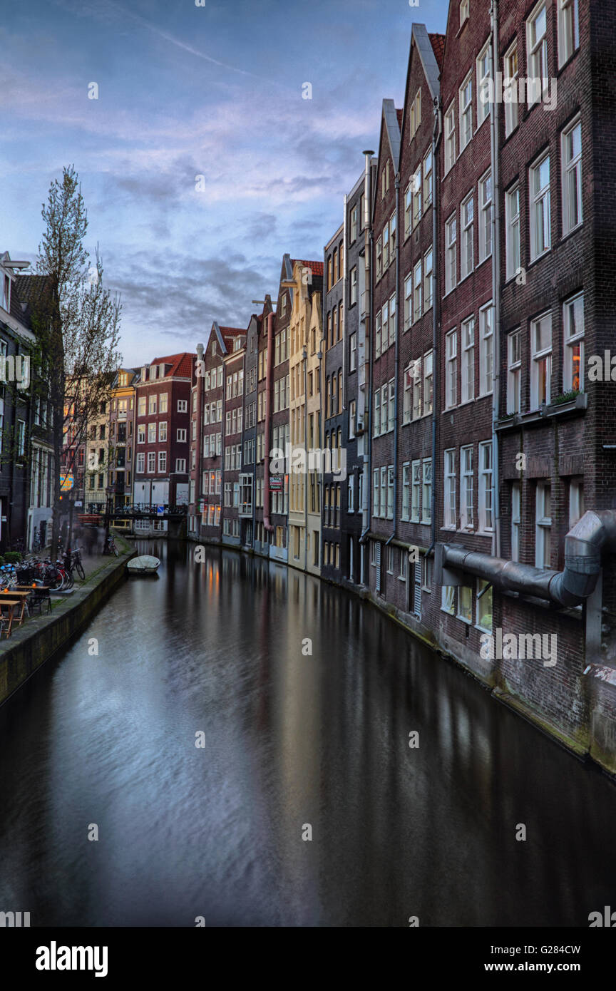Historische Häuser am Oudezijds Achterburgwal am Abend in Amsterdam, Niederlande, Europa. Stockfoto