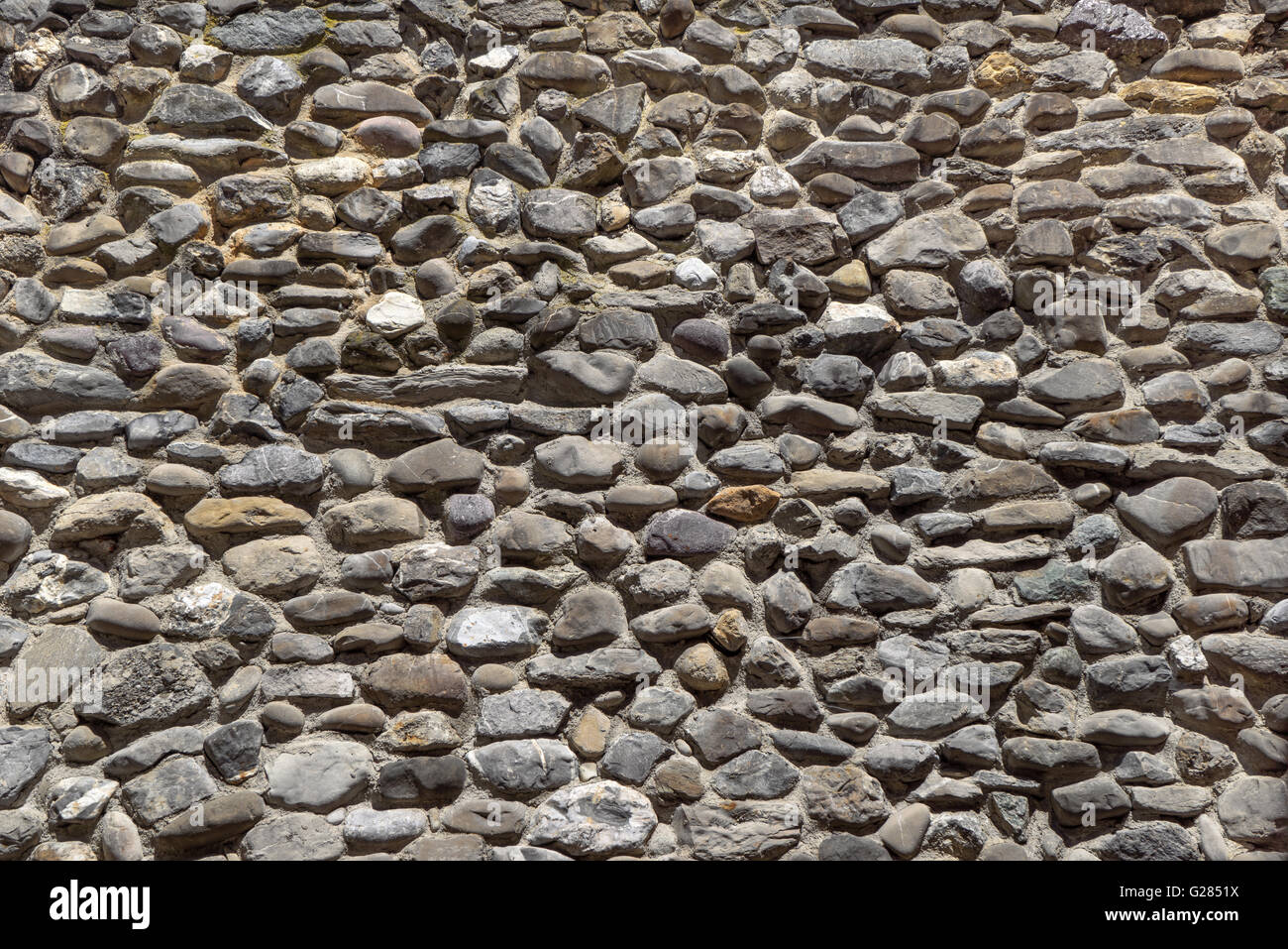 Alte Mauer grau gerundet Natursteine Stockfoto