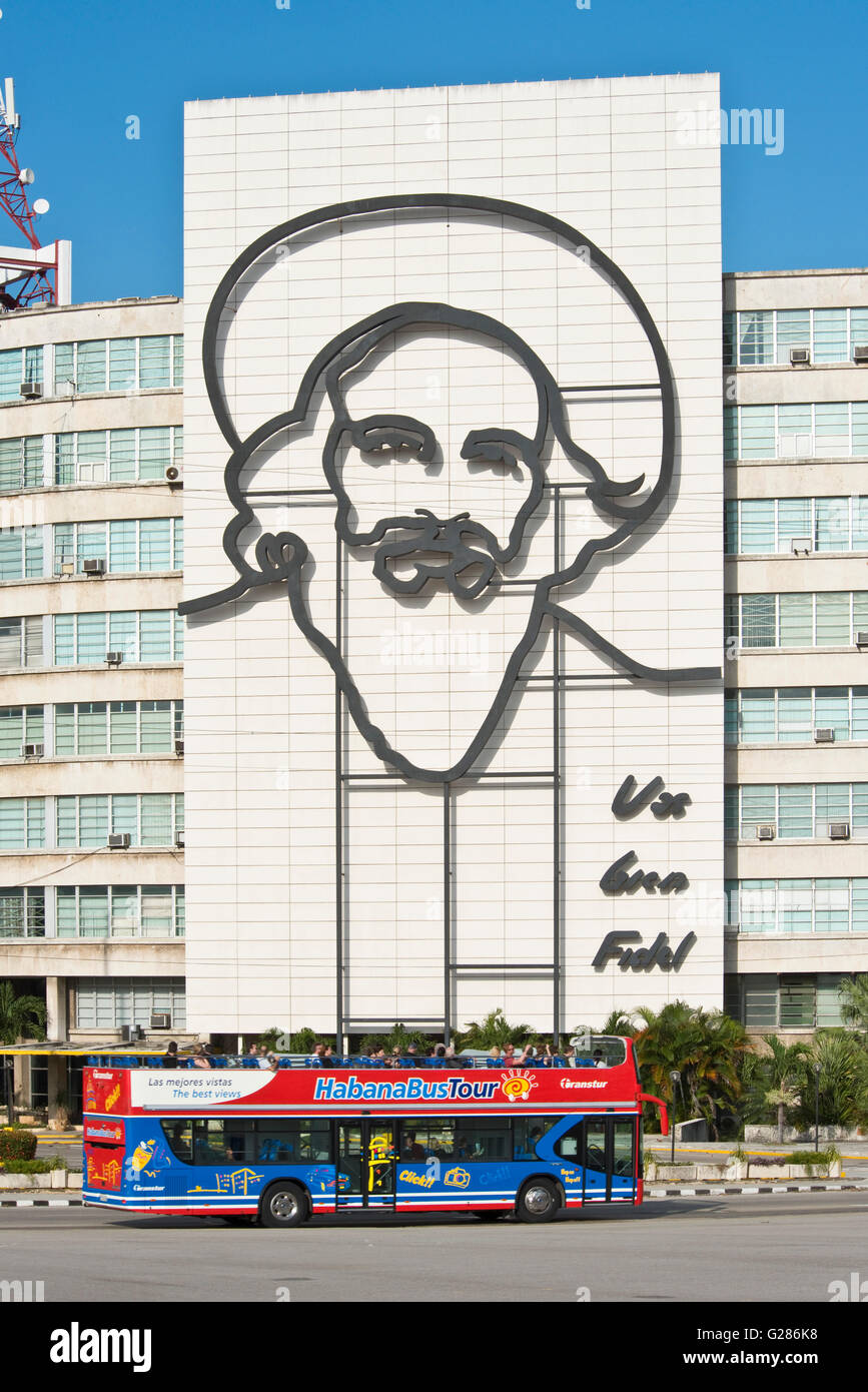 Ein Tourist Havanna La Habana Hop on Hop off-Bus am Platz der Revolution mit dem Bild von Camilo Cienfuegos im Hintergrund. Stockfoto