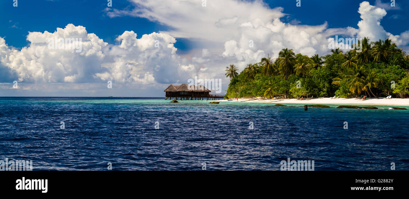 Über Wasser-Bungalows auf einer tropischen Insel mit Palmen und lebhaften Strand. Tropischen Panorama Hintergrund Konzept Stockfoto