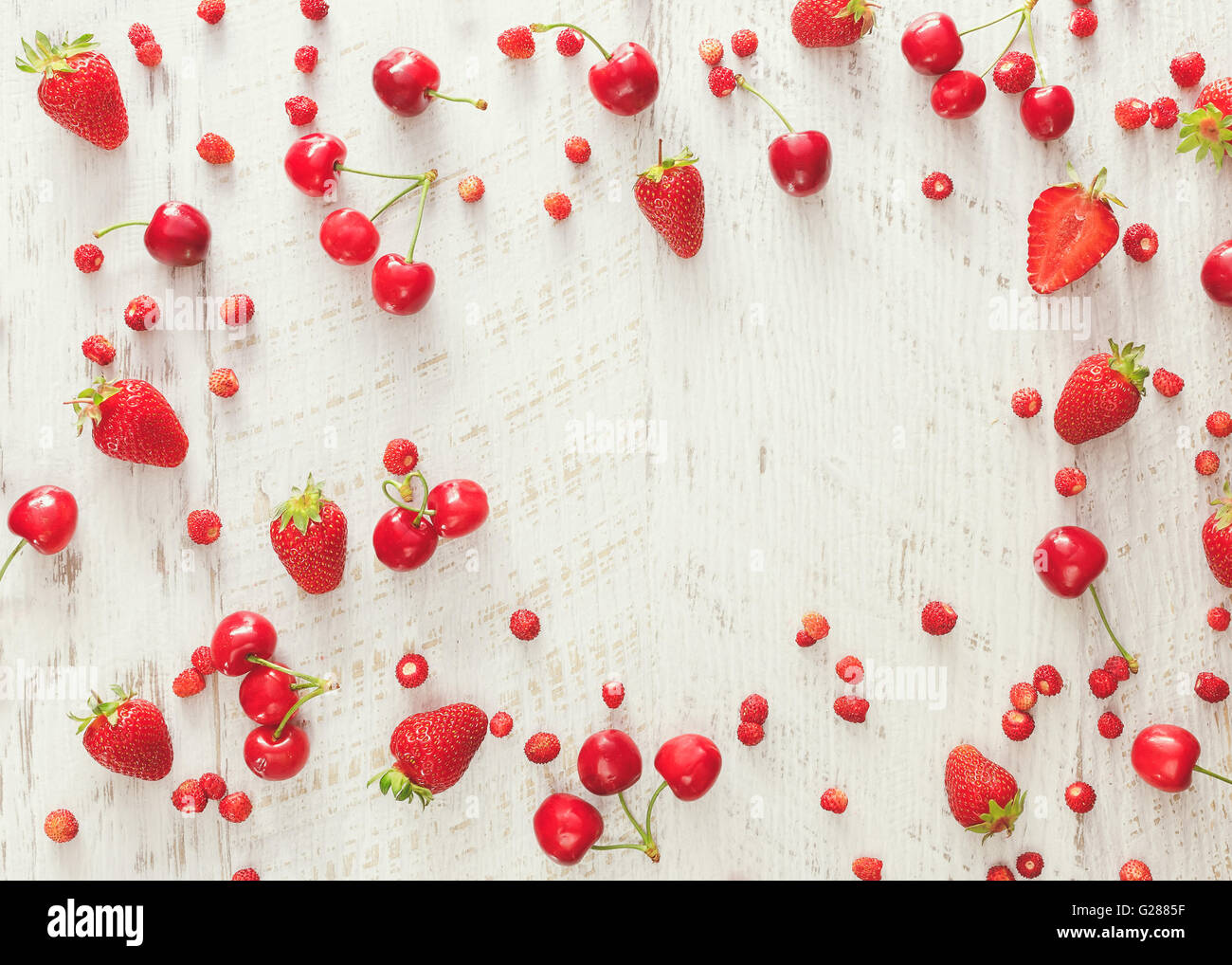 Beerenfrucht. Frische Bio Beere verstreut auf rustikalen Tisch mit Platz für Text in der Mitte. Draufsicht, Leerzeichen Stockfoto