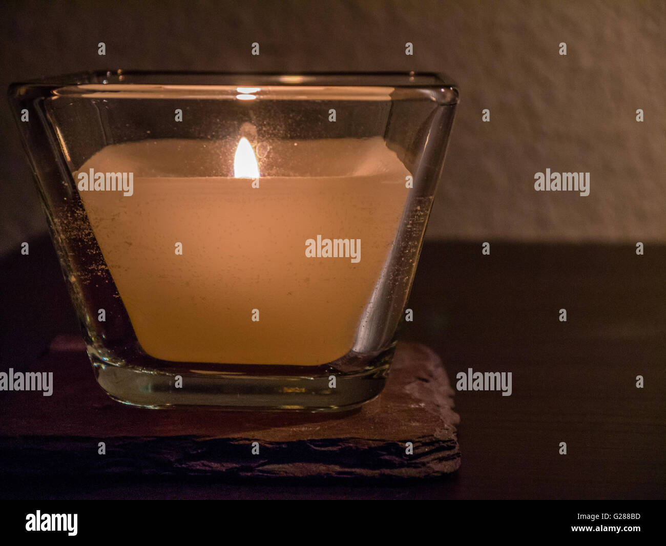 Kerze in Glashalter, neutralem Hintergrund Stockfoto