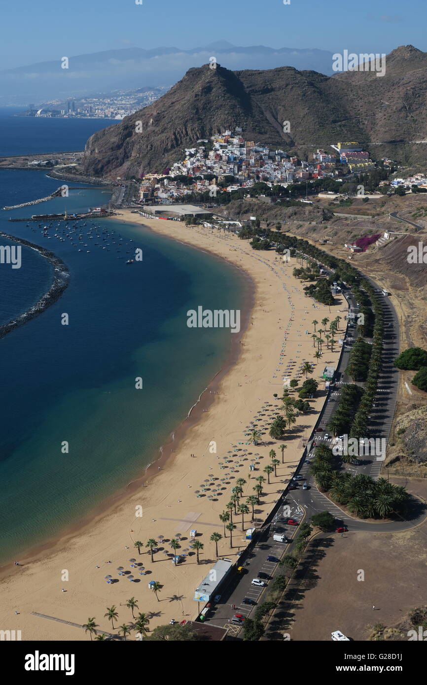 Playa de Las Teresitas mit dem Dorf San Andrés thront auf dem Berghang und Santa Cruz De Tenerife in weiter Ferne Stockfoto