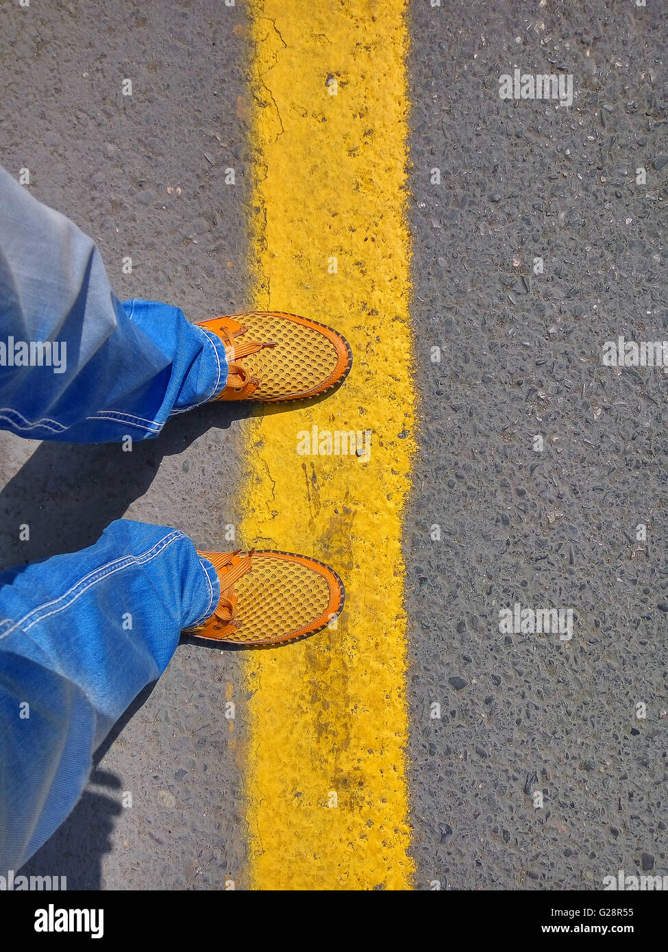 Mann in Jeans und eine gelbe Schuhe stehend auf das gelbe band Stockfoto