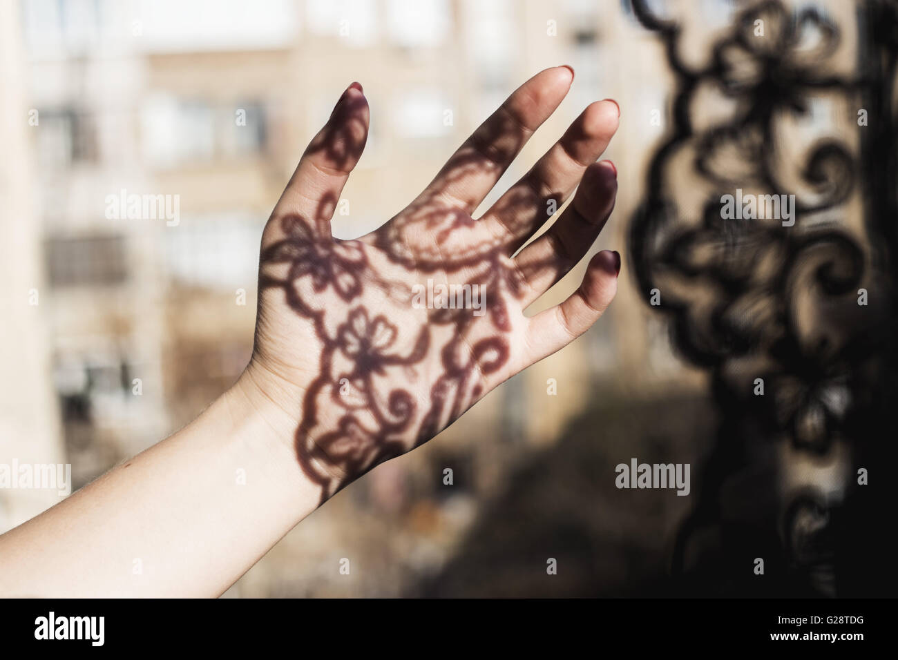 Schatten von einem Vorhang in Frauenhand Stockfoto
