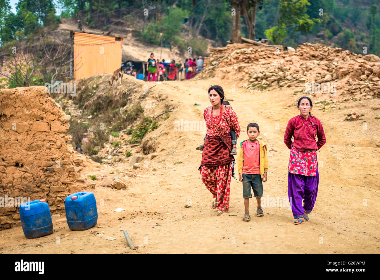 Nepalesische Frauen und Kinder spazieren auf einer unbefestigten Straße in Chandeni (Chandani), Mandan Village, Kavrepalanchowk District, Nepal. Stockfoto