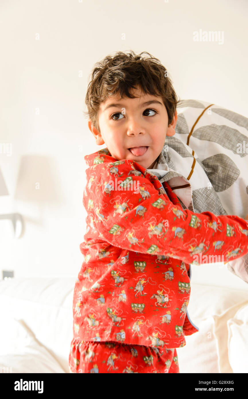 Kind spielt auf Bett in ein pijama Stockfoto