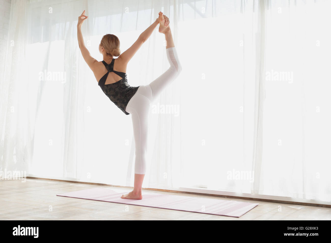 Attraktive junge Japaner praktizieren Yoga in einem luftigen Raum Stockfoto