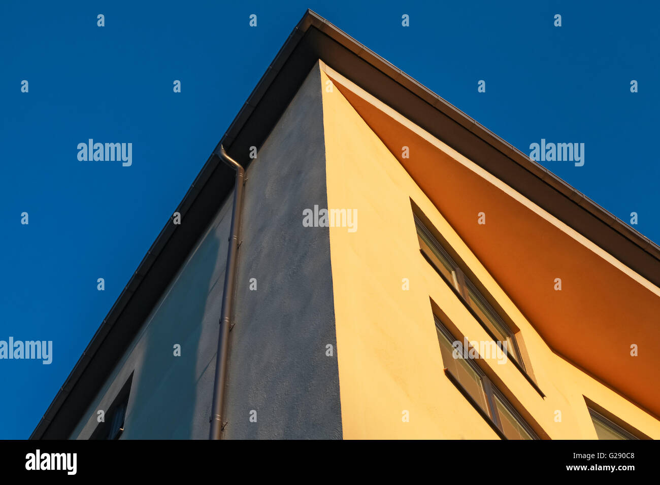 Abstrakte Fragment der Gegenwartsarchitektur, gelbe Wände unter tiefblauem Himmel Stockfoto