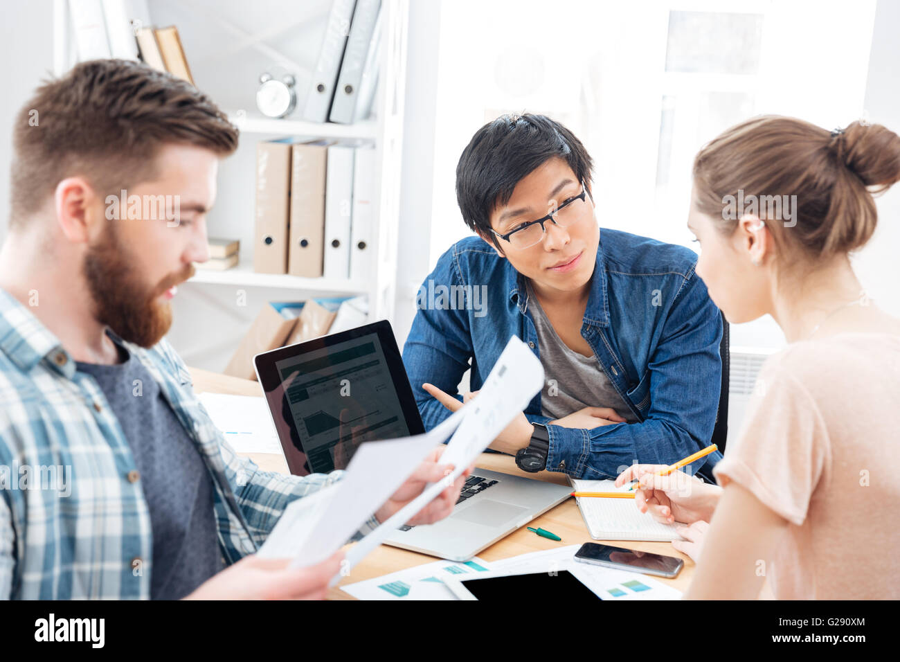 Drei schwere junge Unternehmer sitzen und gemeinsam im Büro Stockfoto