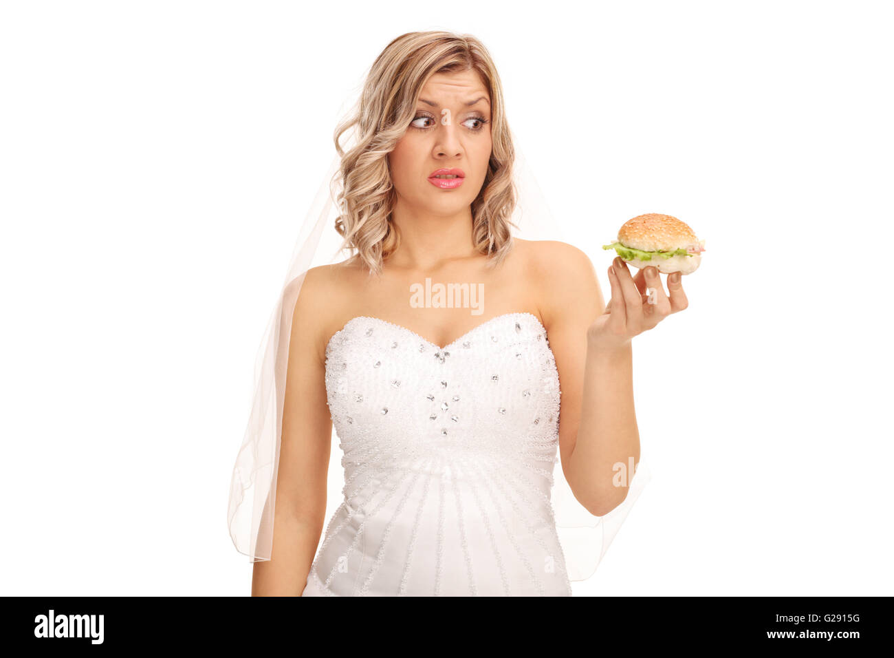Unentschlossen Braut Blick auf eine verlockende Sandwich isoliert auf weißem Hintergrund Stockfoto