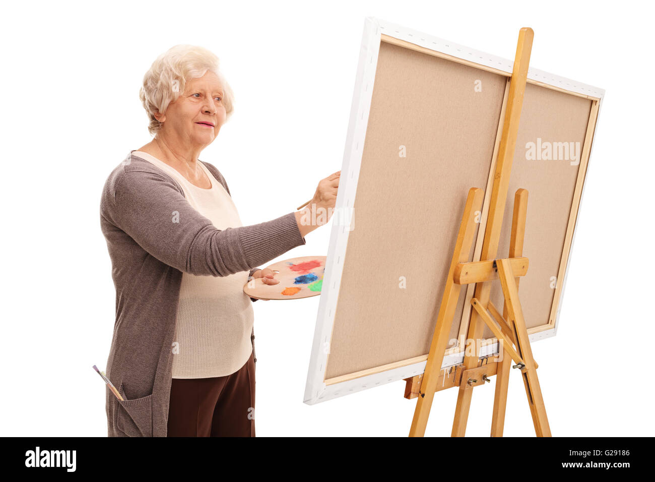 Leitende Künstlerin Malerei auf Leinwand mit einem Pinsel isoliert auf weißem Hintergrund Stockfoto