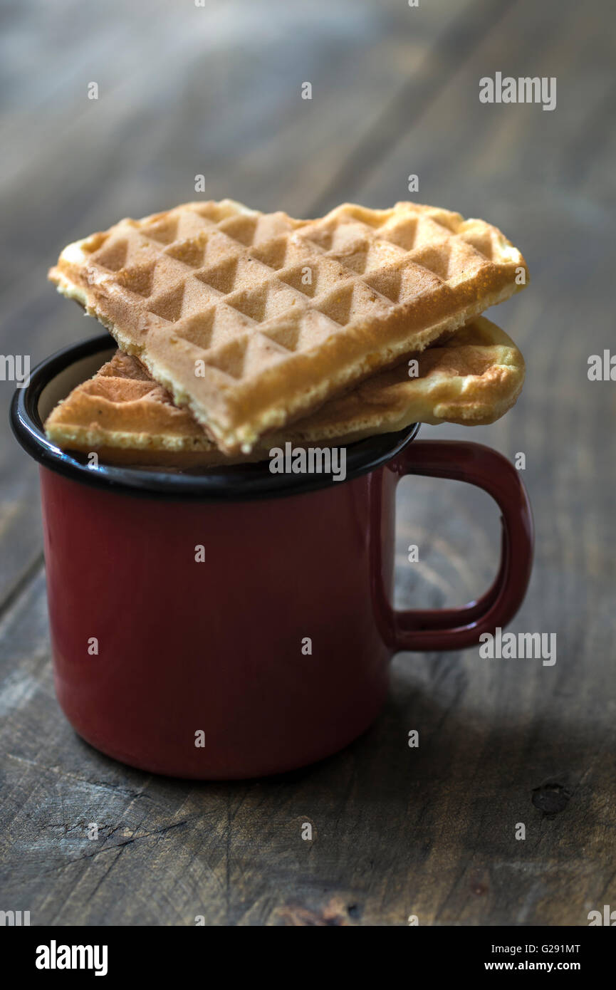 herzförmige Waffeln und Kaffee am Tisch in der Nähe von Stockfoto