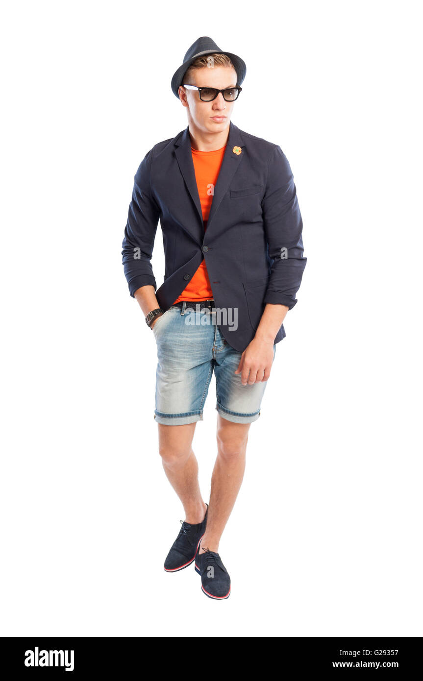 Männliche Fotomodell posiert mit Unky Jackett, kurze Jeans, ausgefallene Hut und Sonnenbrille Stockfoto