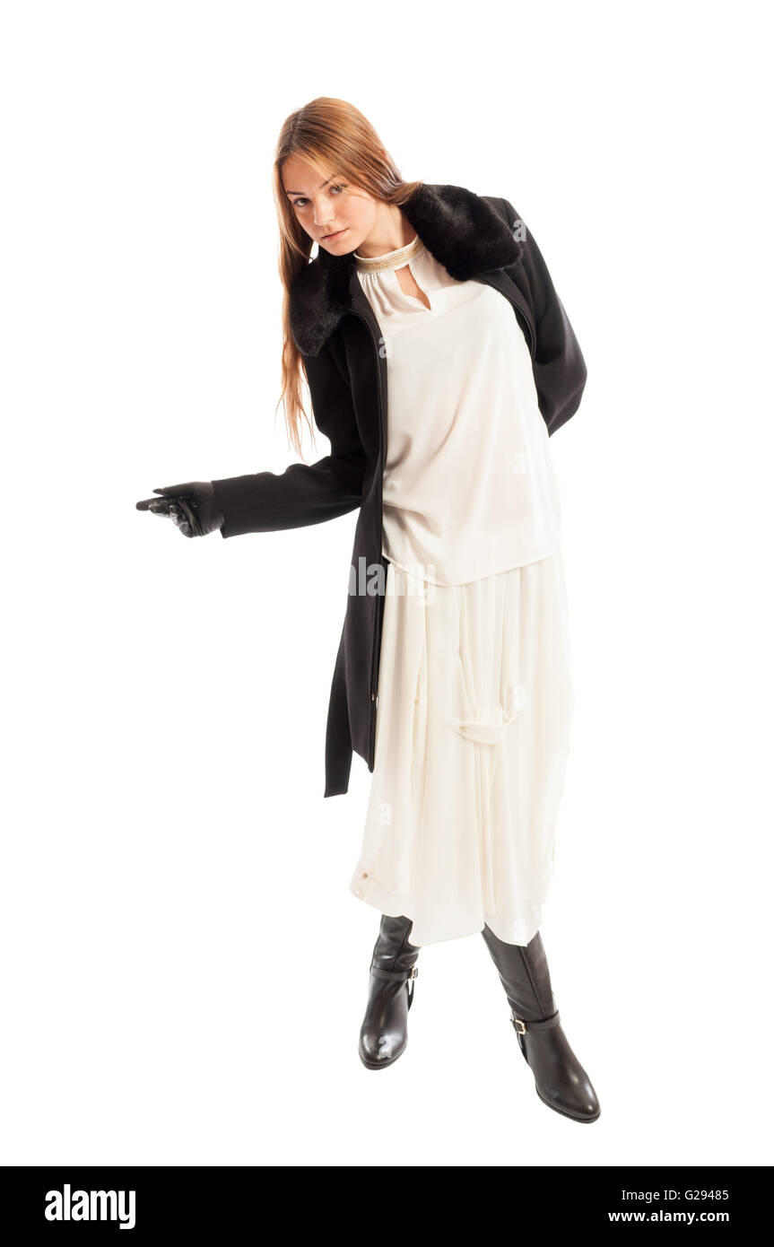 Weibliches Model, das Tragen von schwarzen Mantel und weißen Kleid während  posiert auf weißem Hintergrund Stockfotografie - Alamy