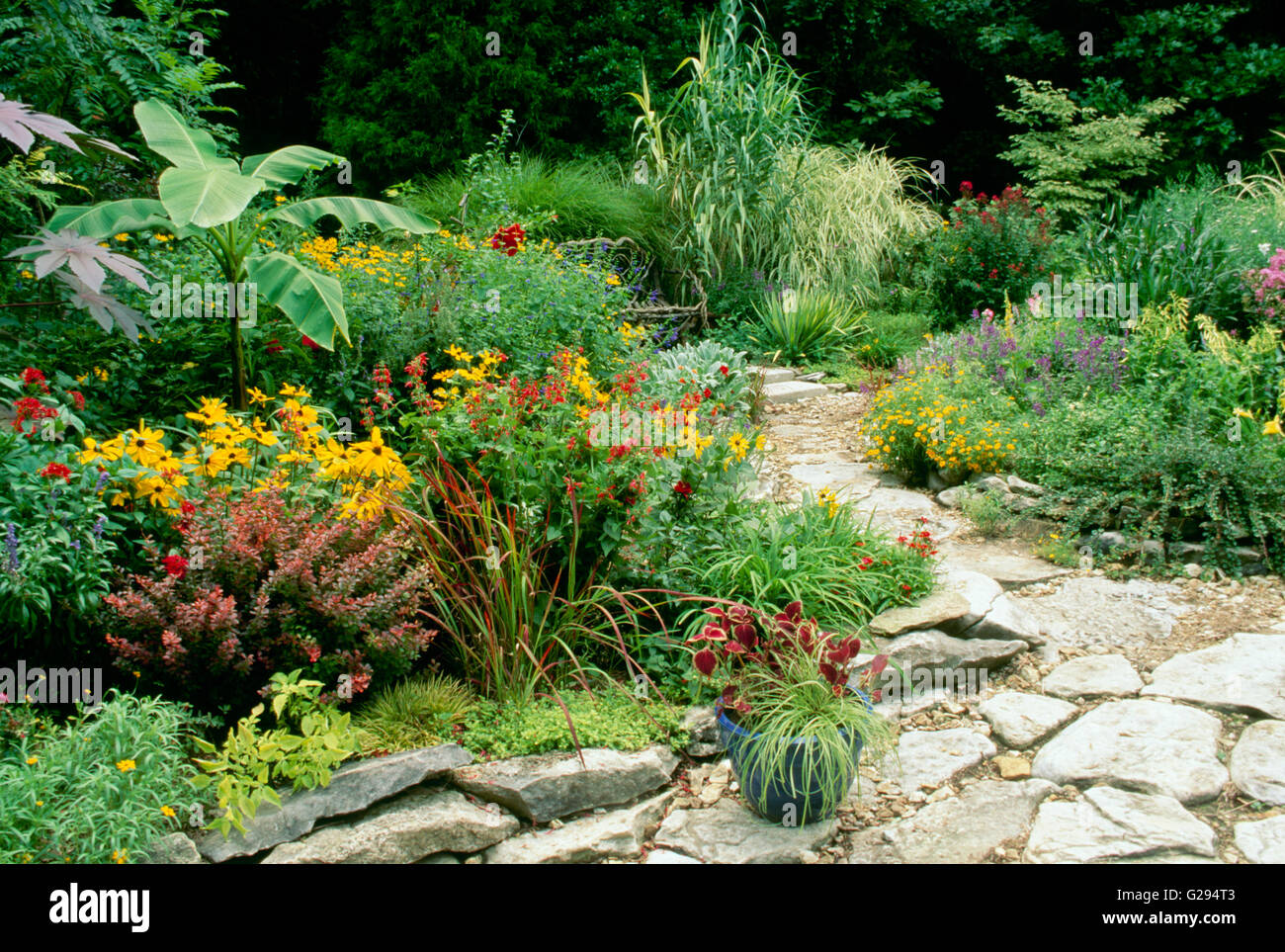 Schönen blühenden Garten rot und Orange mit Felsen Weg, Missouri USA Stockfoto