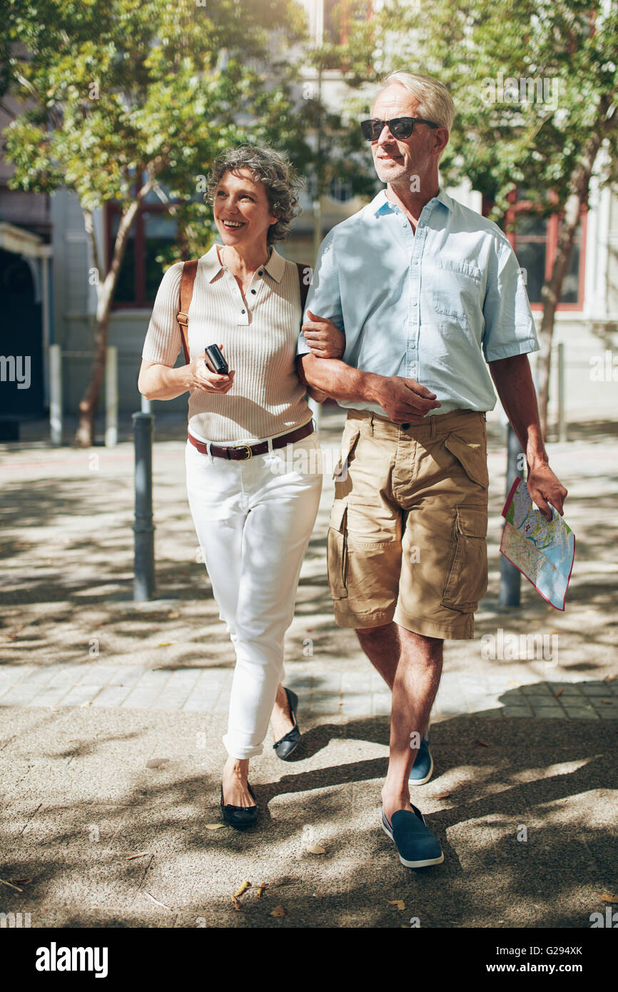 Älteres Paar zu Fuß durch die Stadt im Besitz einer Karte. Glücklich senior Mann und Frau in den Urlaub. Stockfoto