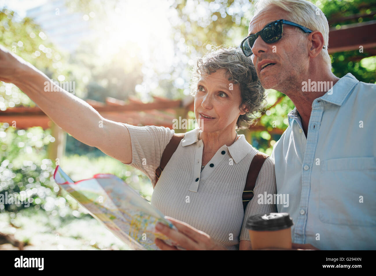 Älteres Paar auf einen Urlaub mit Frau, die im Besitz einer Karte zeigt auf einen Blick. Stockfoto