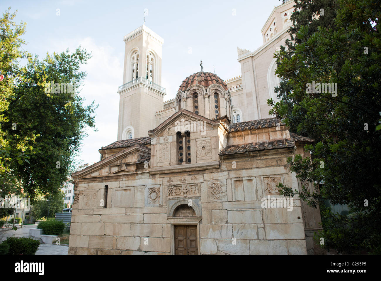 ATHEN, Griechenland - die winzige Agios Eleftherios Kirche (auch Mikri Mitropoli genannt) stammt aus dem 13. Jahrhundert und befindet sich neben der viel größeren Metropolitankathedrale von Athen 9im Hintergrund). Stockfoto