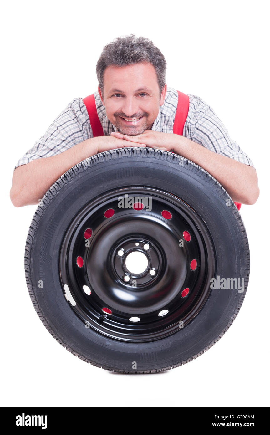 Lächelnde Mechaniker ruhen Kopf auf Reifen isoliert auf weißem Hintergrund Stockfoto