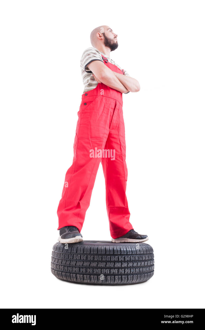 Held im niedrigen Winkel der Mechaniker stehend auf Auto-Rad nach oben isoliert auf weiss gedreht Stockfoto