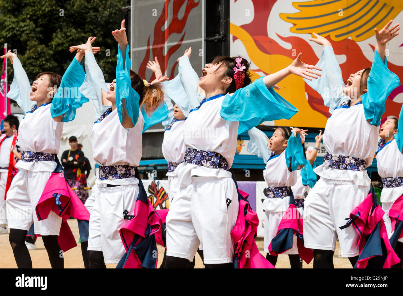 Frauen Mannschaft in weiß und türkis happi Jacken, Tanzen im Freien, in Reihen, während der Hinokuni Yosakoi Dance Festival in Kumamoto, Japan. Stockfoto