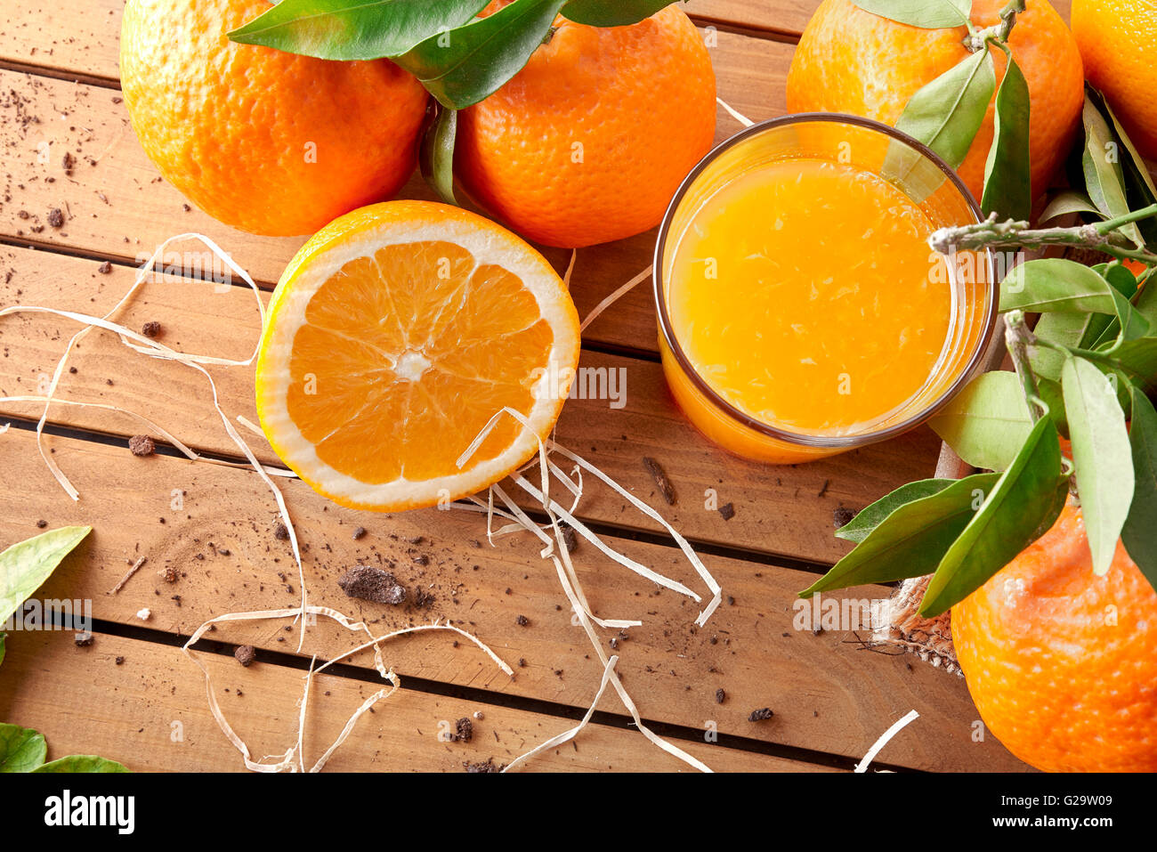 Glas Orangensaft auf einem Holztisch mit Orangen und orange Abschnitte. Horizontale Komposition. Ansicht von oben Stockfoto