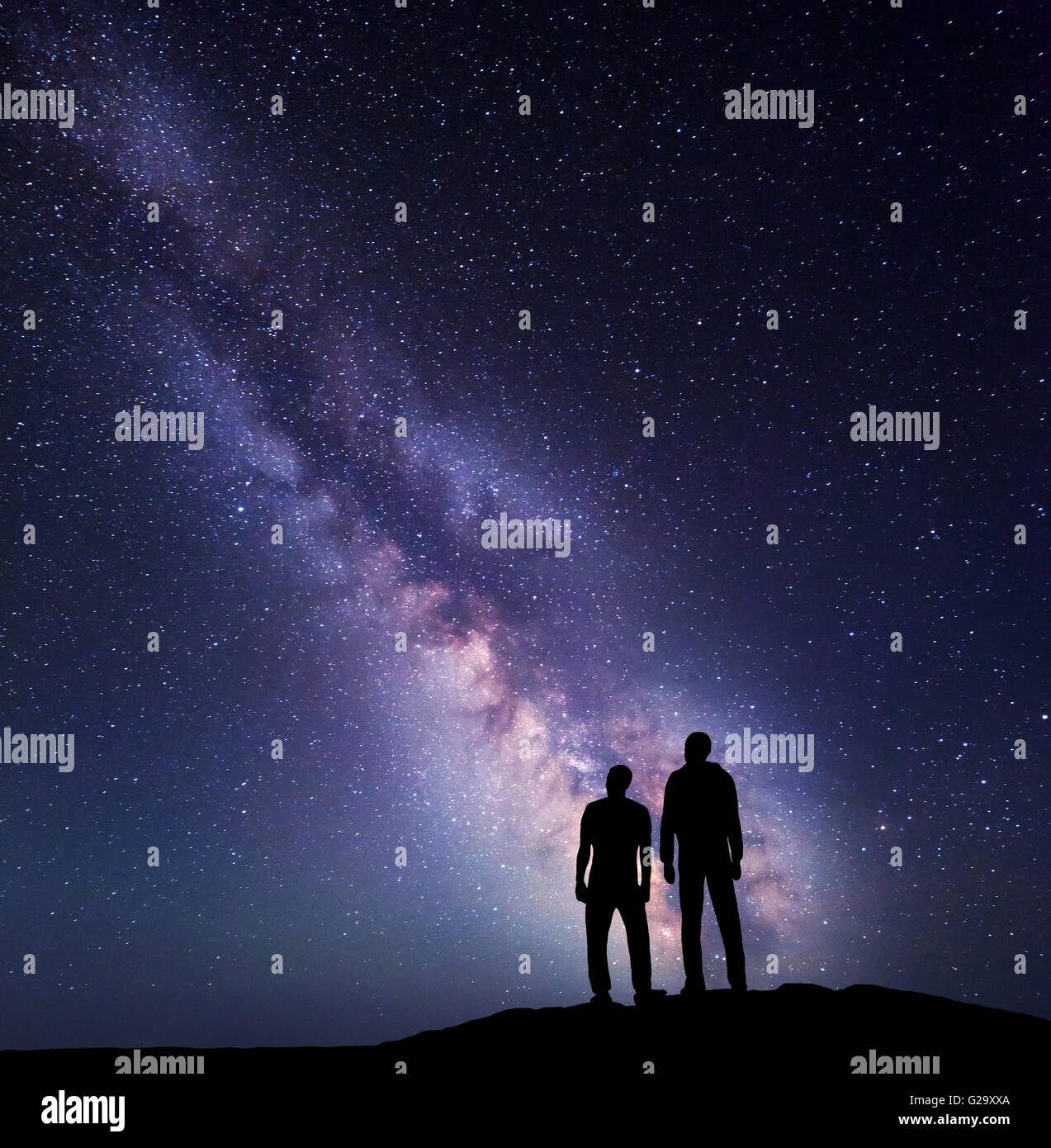 Silhouette einer Familie auf dem Berg. Vater und Sohn auf dem Hintergrund der Milchstraße. Nacht-Landschaft. Schöne Universum. S Stockfoto