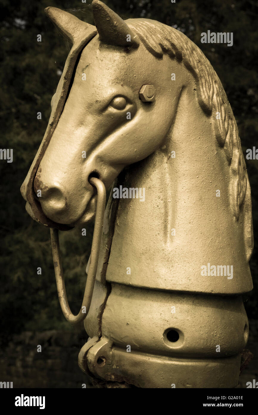 Eine alte und verwitterte Gusseisen Pferd Hitching Post aus dem 19. Jahrhundert steht Wache und edlen herrschaftlichen Garten Stockfoto
