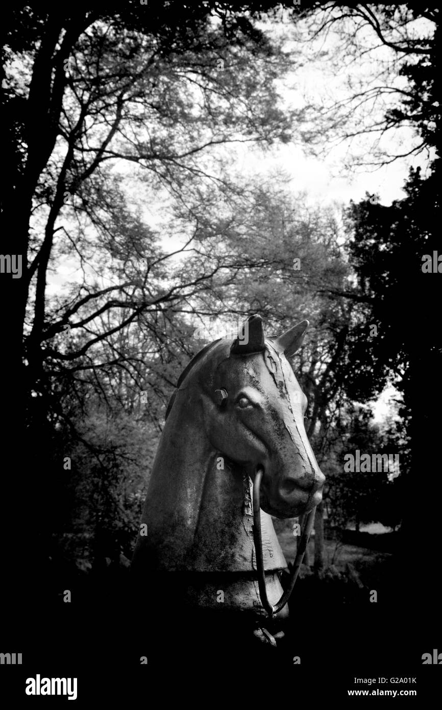 Eine alte und verwitterte Gusseisen Pferd Hitching Post aus dem 19. Jahrhundert steht Wache und edlen herrschaftlichen Garten Stockfoto