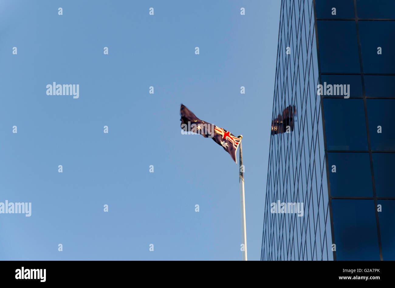 Eine australische Flagge fliegen und spiegelt in einem nahe gelegenen Gebäude Stockfoto