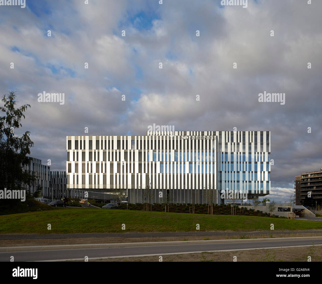 Vorderansicht der Außenfassade mit bewölktem Himmel. Fornebuporten, Oslo, Norwegen. Architekt: Dunkel, 2015. Stockfoto