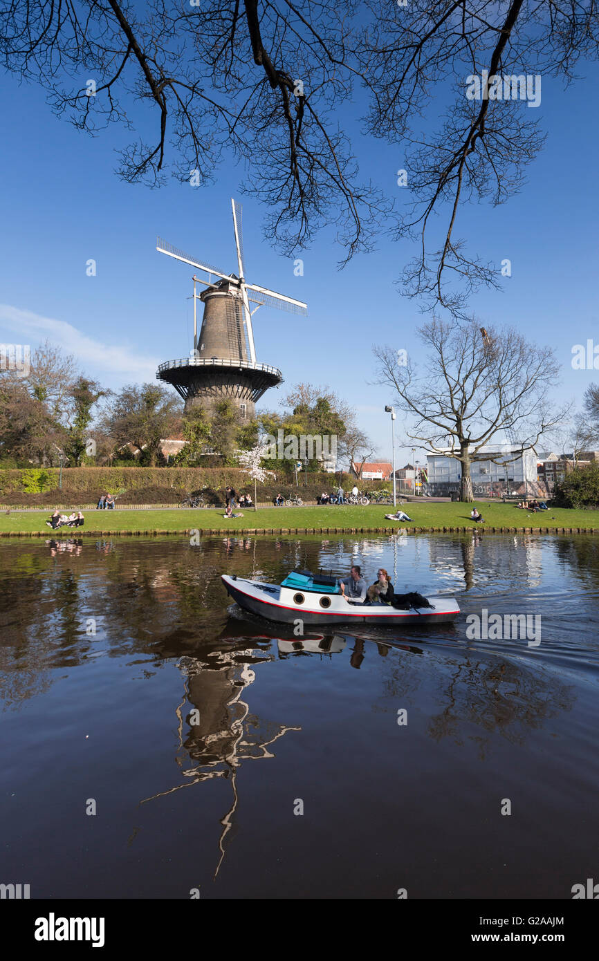 Ein Motorboot auf dem Rhein geht durch Molen de Valk, Leiden, Niederlande. Stockfoto