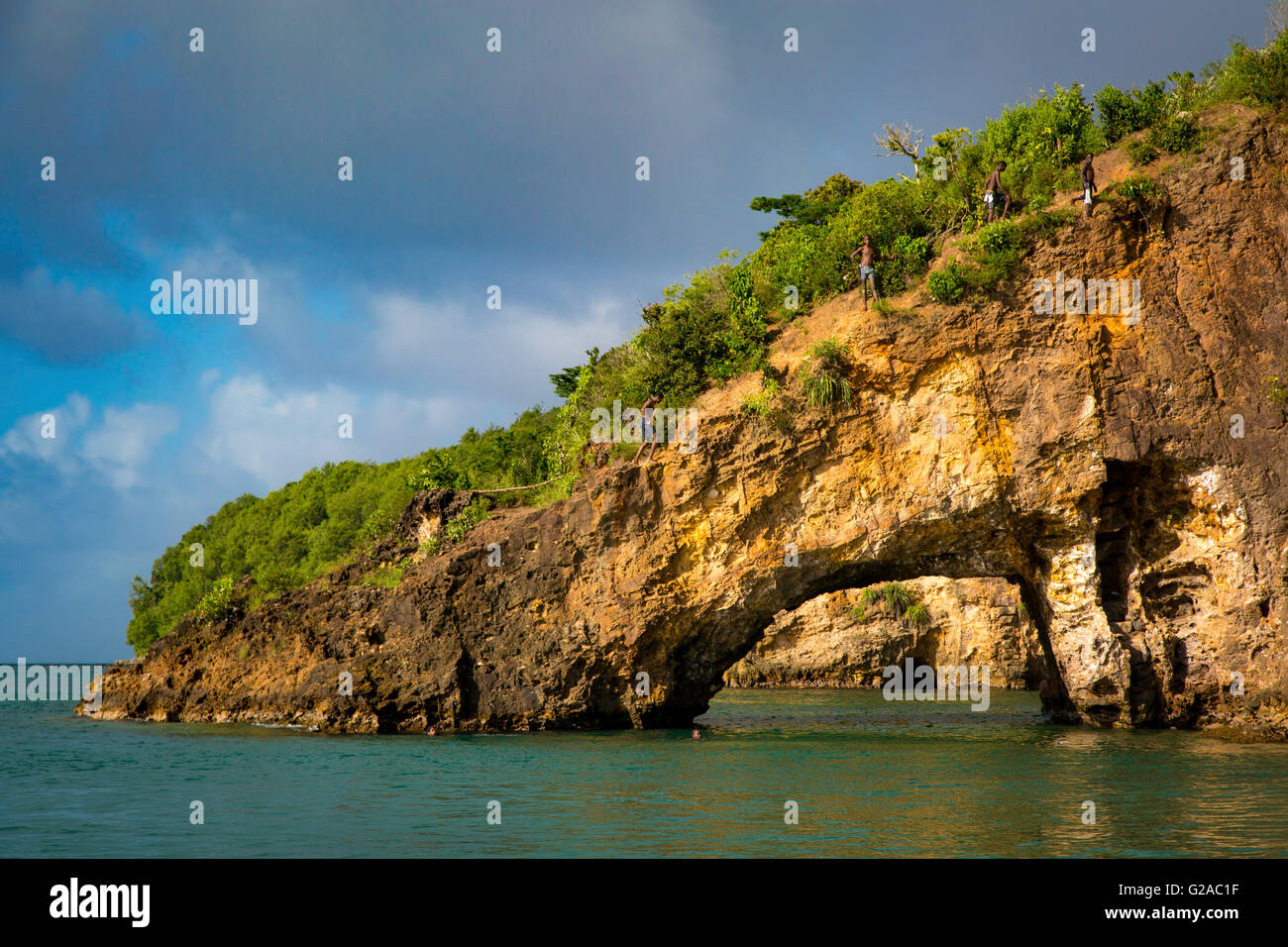 Lokale Insel Kinder klettern auf den Felsen ins Meer, St Lucia, West Indies springen Stockfoto