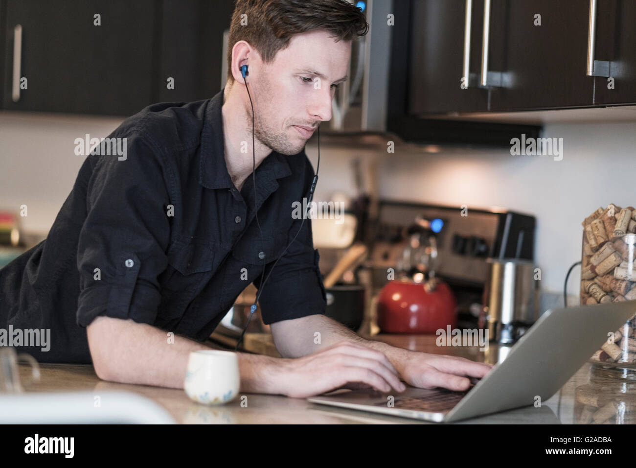 Mann arbeitet auf Laptop-Computer in der Küche Stockfoto