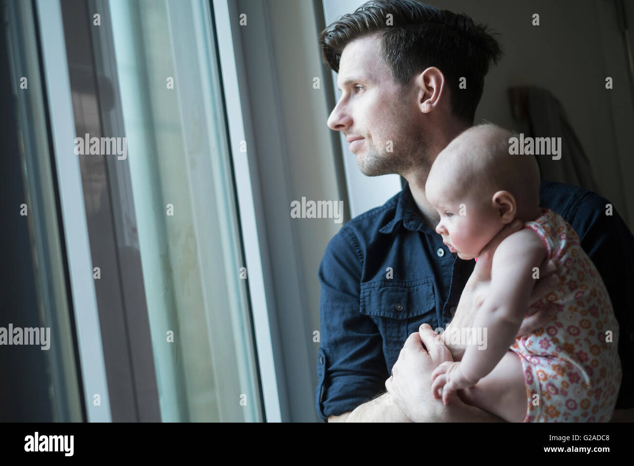 Vater Blick durch Fenster mit Tochter (2-5 Monate) Stockfoto