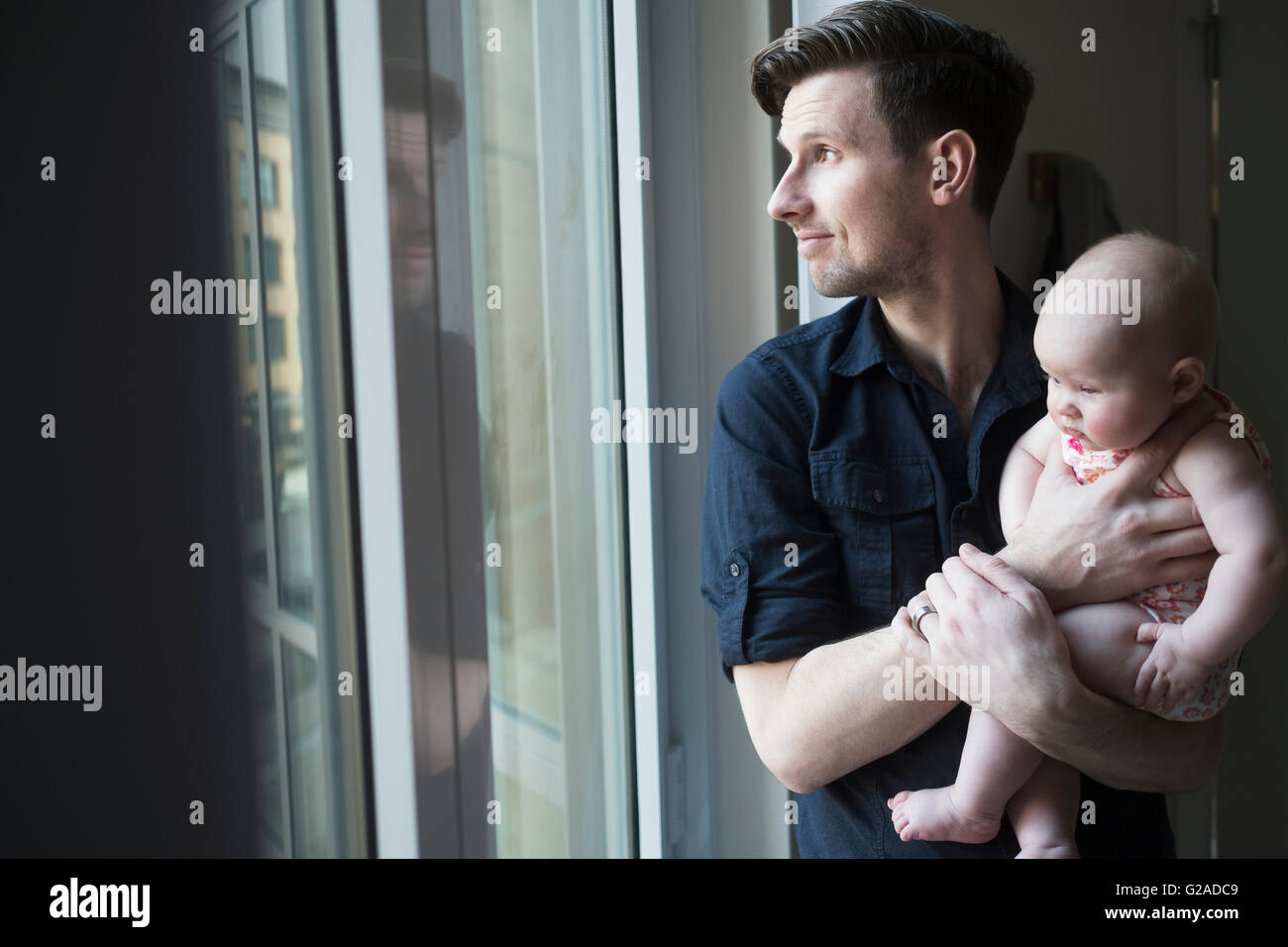 Vater Blick durch Fenster mit Tochter (2-5 Monate) Stockfoto