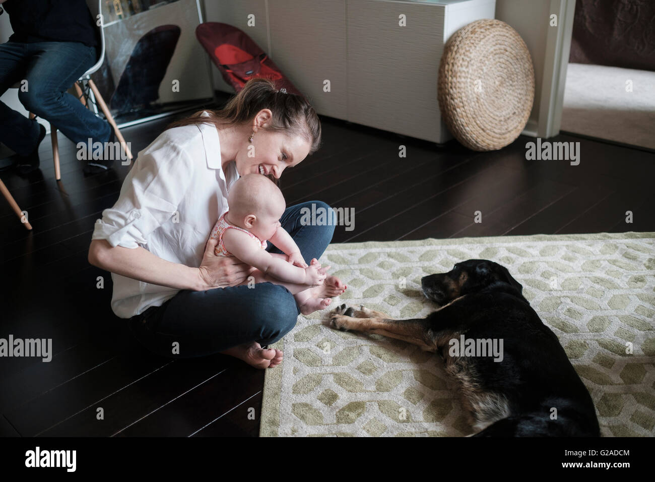 Mutter mit Baby (2-5 Monate) und spielen mit Hund Stockfoto
