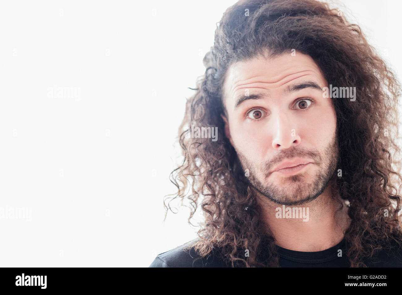 Porträt des jungen Mannes mit langen lockigen Haaren Stockfoto
