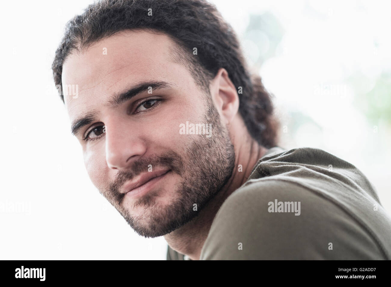 Porträt des jungen Mannes mit langen lockigen Haaren Stockfoto
