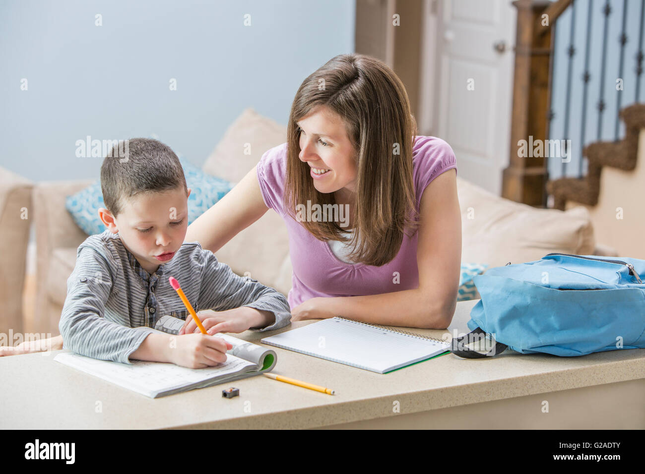Mutter hilft Sohn (6-7) machen Hausaufgaben Stockfoto