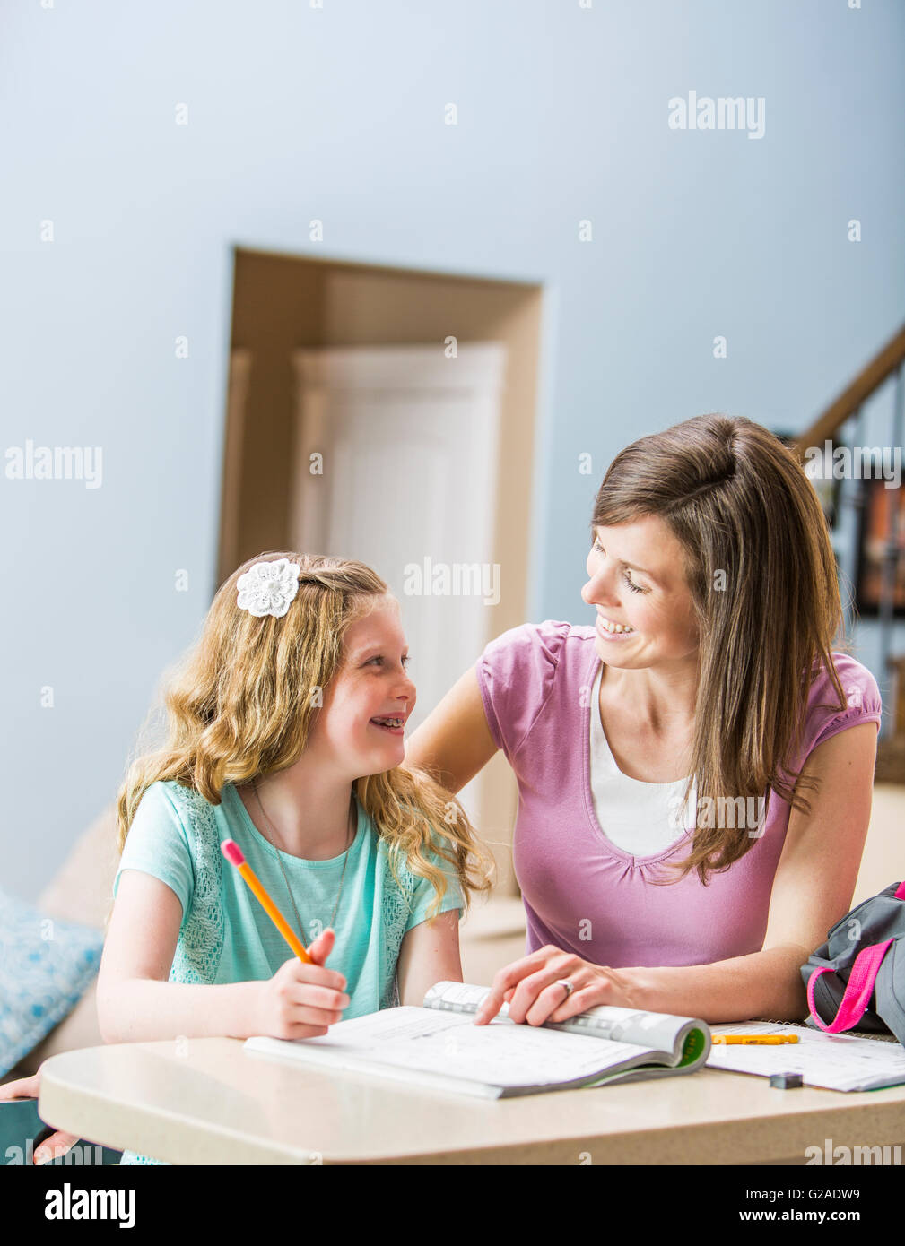Mutter und Tochter (8-9) sitzen am Tisch, die Hausaufgaben Stockfoto