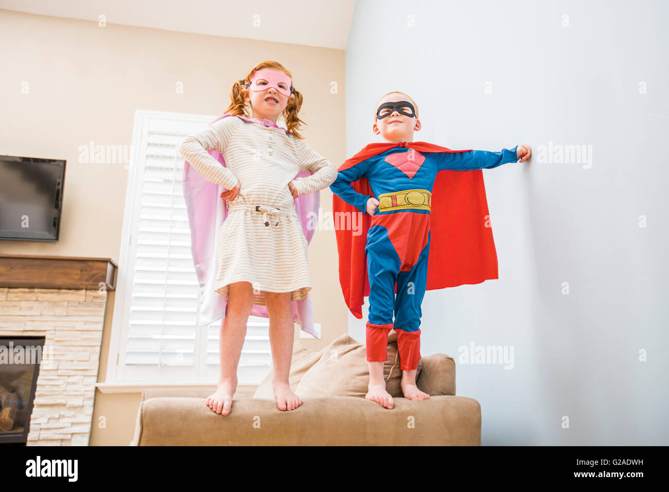 Kinder (2-3, 4-5) spielen Superheld auf sofa Stockfoto