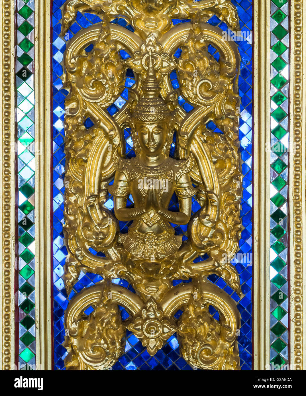 Goldene verlangen Engel auf dem blauen Glas von der Tür des Tempels, Thailand. Stockfoto