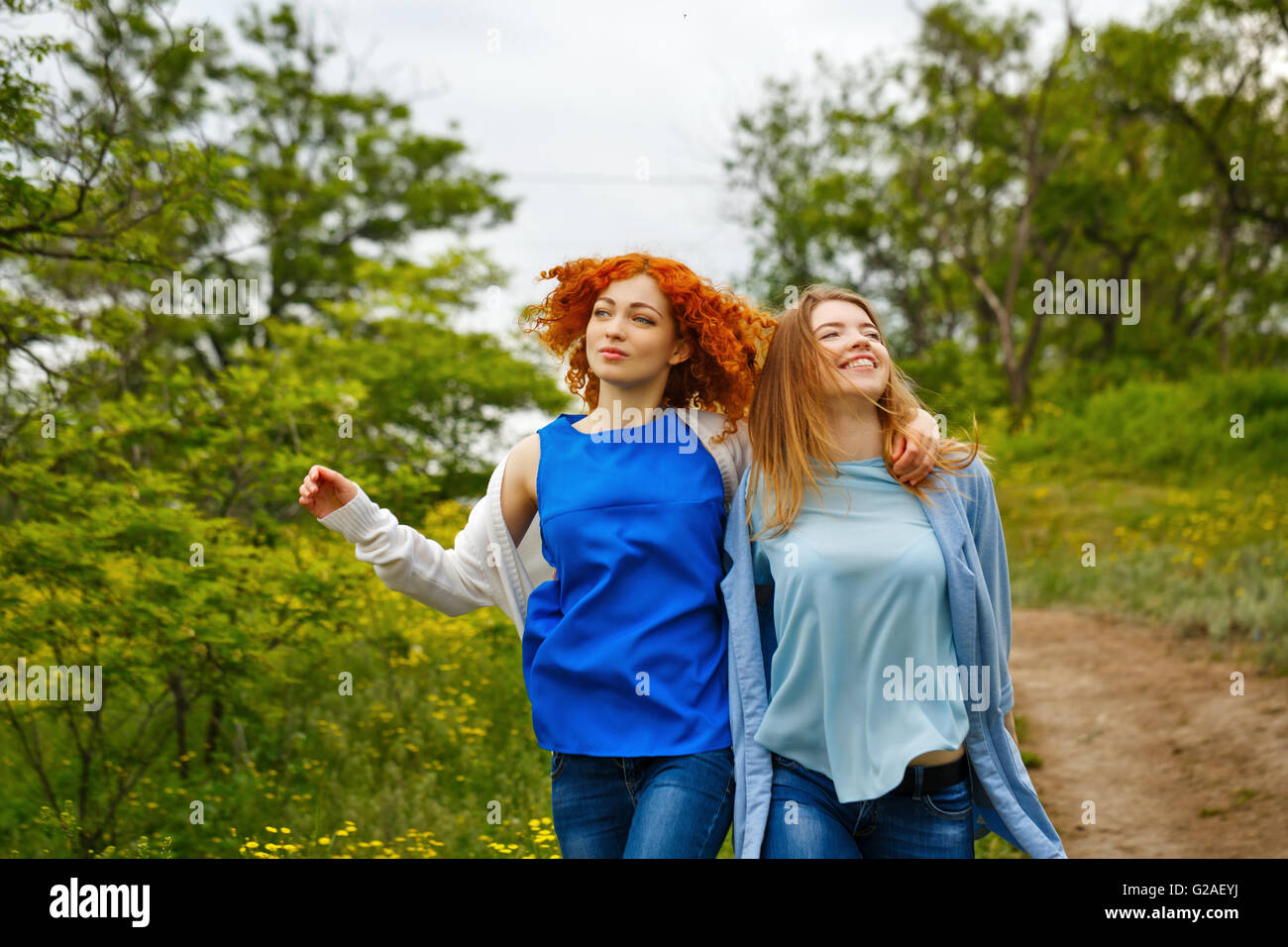 Beste Freunde für immer. Freundinnen, Arm in Arm im Park spazieren. BFF. Enge Freunde. Sanfte Freundschaft. Stockfoto