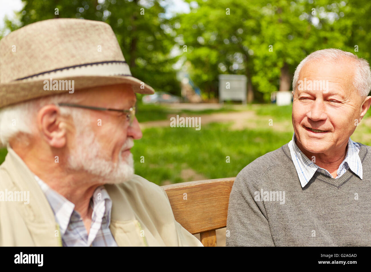 Zwei alte Männer, die in einem Park von einem Altersheim miteinander zu reden Stockfoto