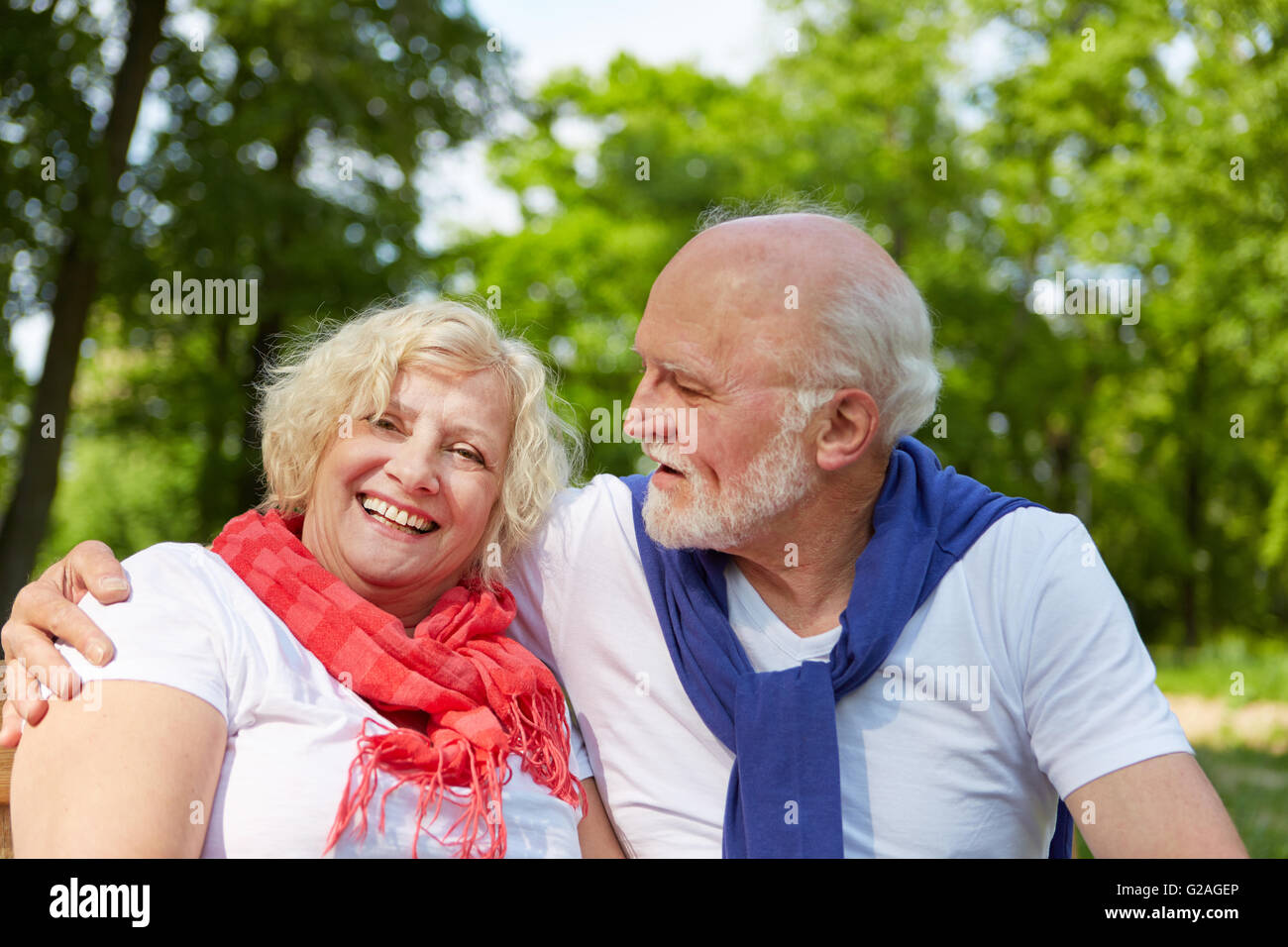 Gerne älteres Paar in Liebe sitzen im Sommergarten Stockfoto
