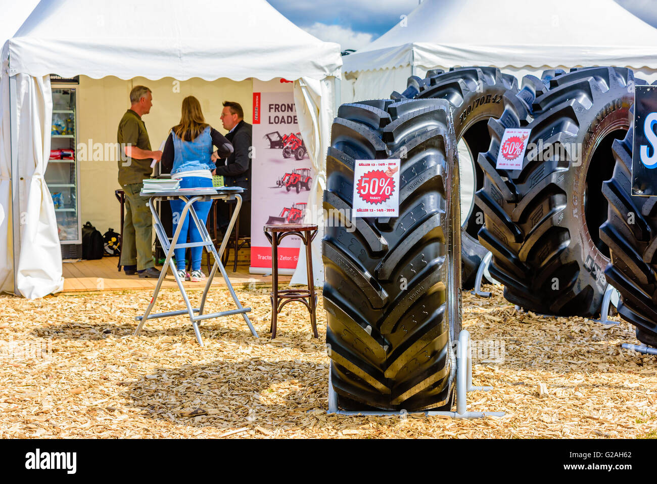 Emmaboda, Schweden - 14. Mai 2016: Wald und Traktor (Skog Och Traktor) fair. Verkauf auf großen Traktorreifen. Verkäufer mit clien Stockfoto