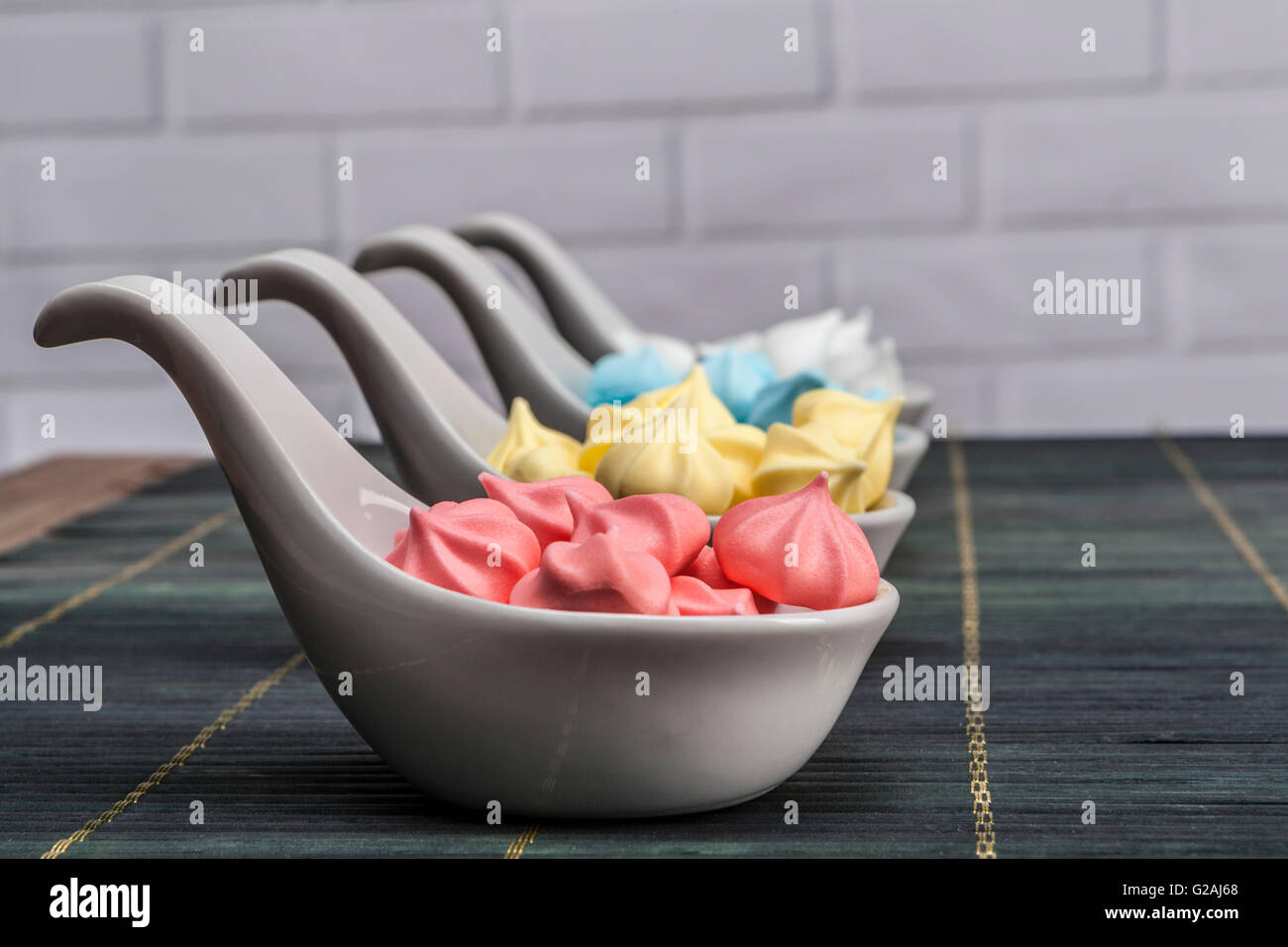 Regenbogen Süßigkeiten auf Tisch und Ziegel Hintergrund Stockfoto