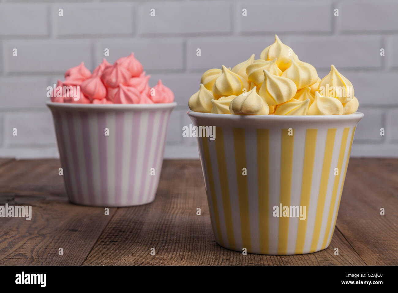 Gelb und rosa Süßigkeiten auf Holztisch Stockfoto